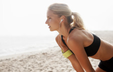 Attractive female jogger taking a rest after a run on the beach